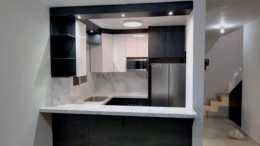 Cocina en U con barra y salpicadero efecto mármol y gabinetes en grafito