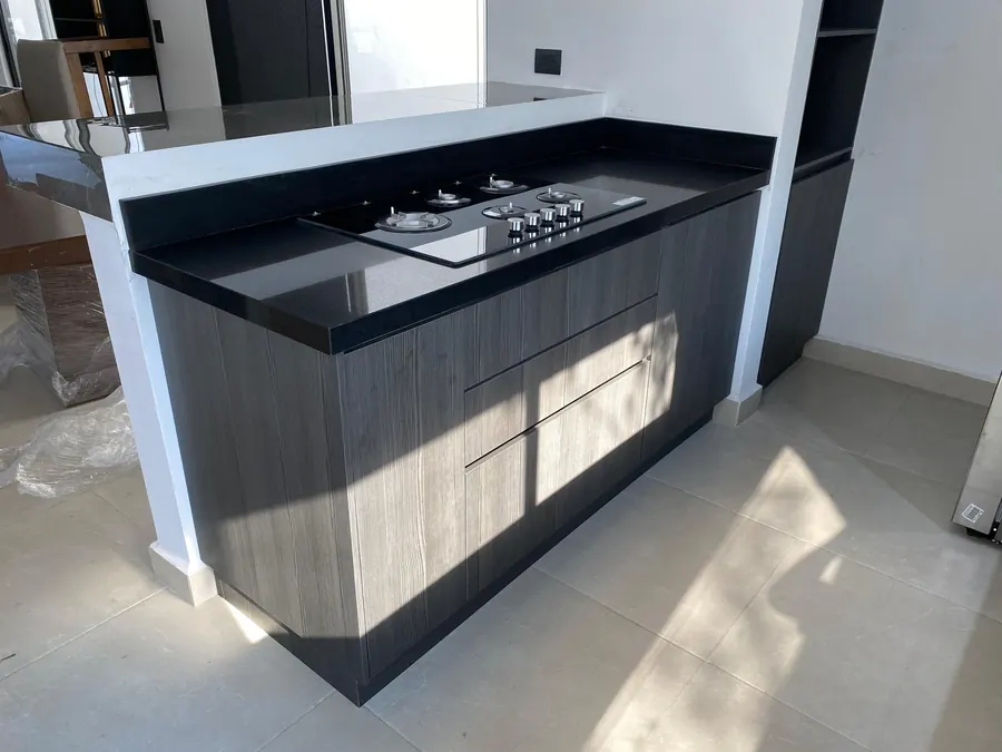 Cocina integral con parrilla empotrada y gabinetes en grafito