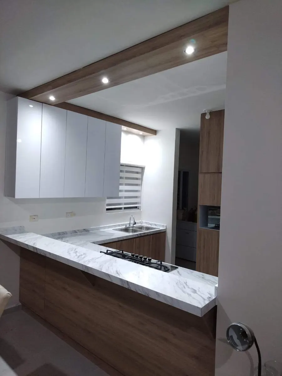 Cocina en roble con alacenas blanco alto brillo y cubierta efecto mármol